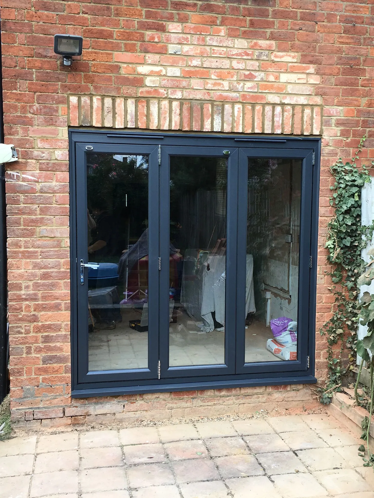 Anthracite grey UPVC bi-fold doors installed in a brick property