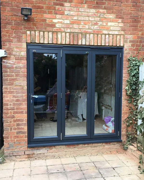 Anthracite grey UPVC bi-fold doors installed in a brick property