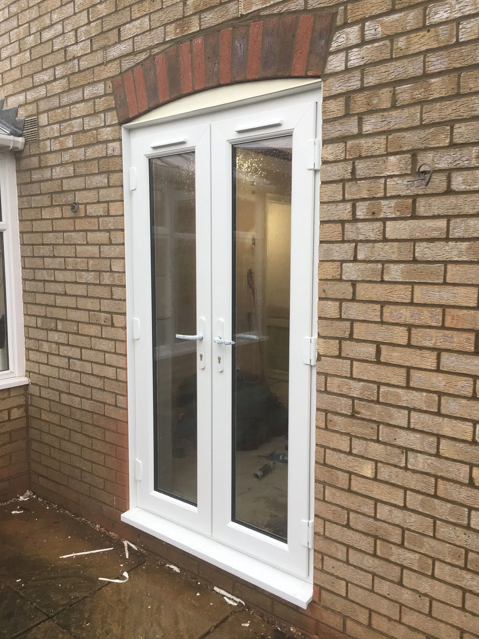 White UPVC French doors installed in a brick property