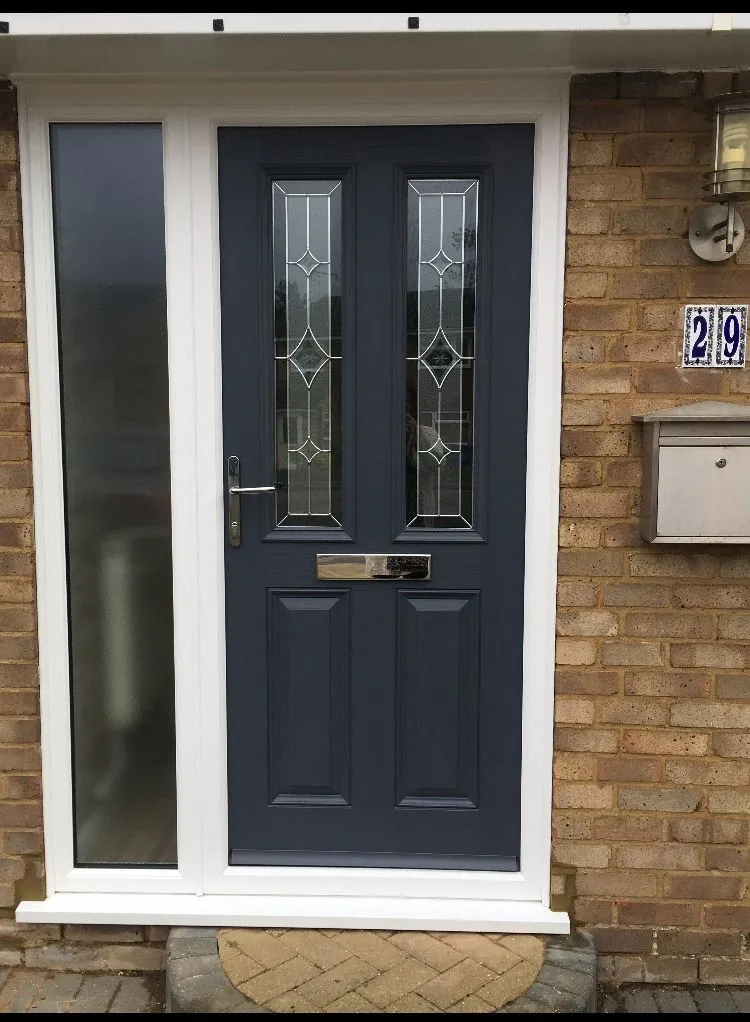 Grey composite front door with decorative glass panels and frosted side panel
