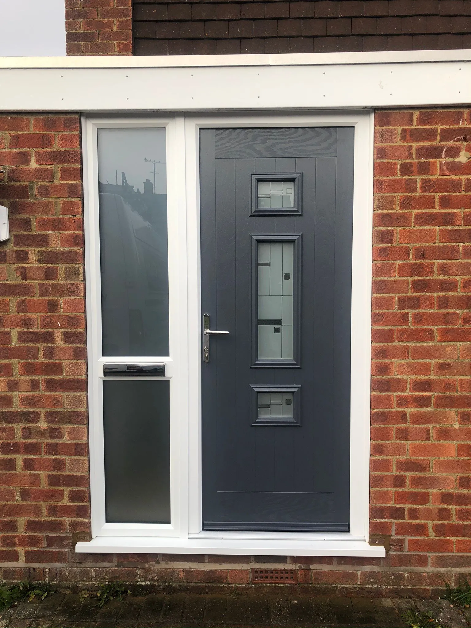 Grey composite door with three square decorative glass panels and side windows