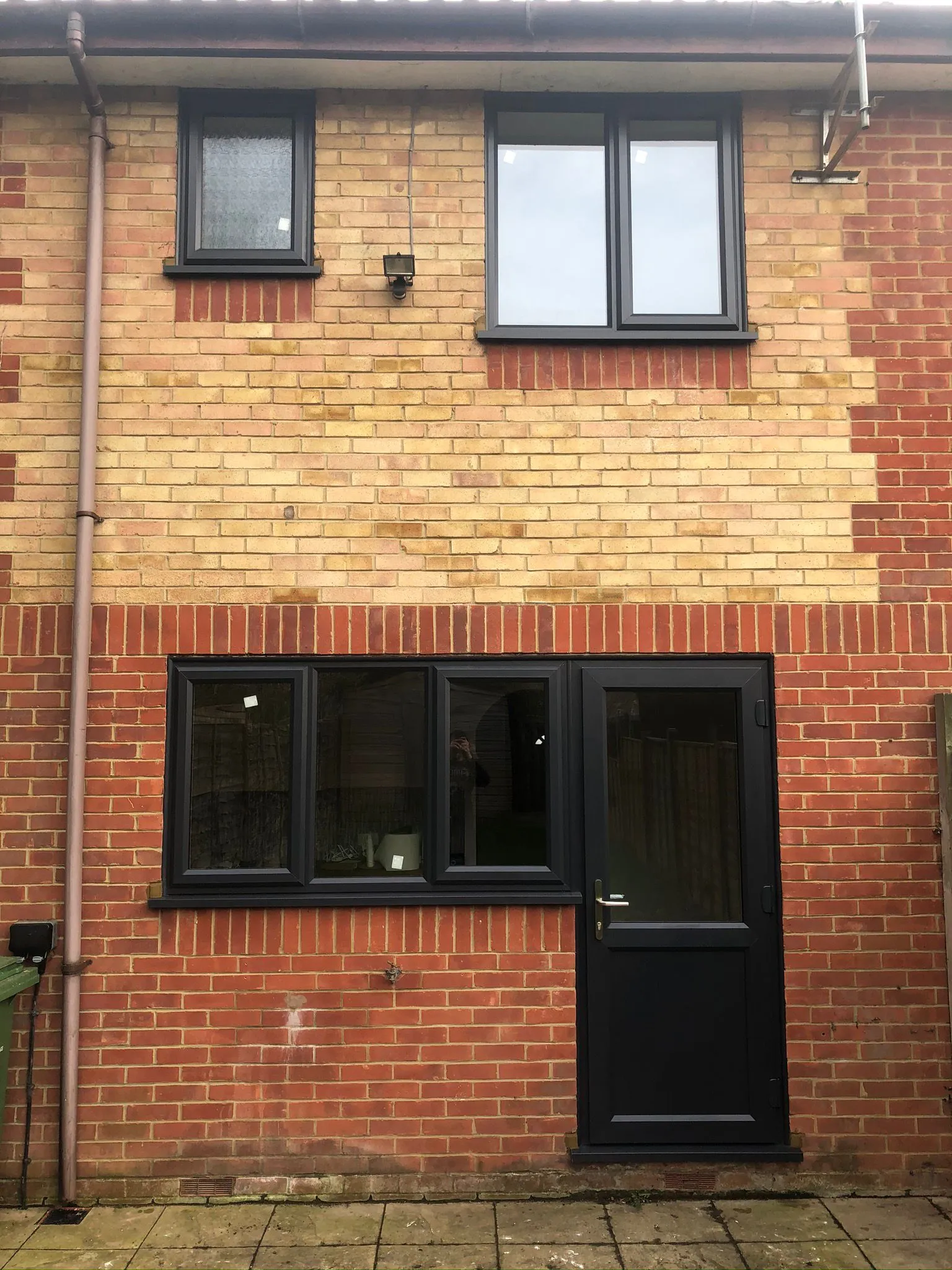 Grey UPVC windows and rear back door on brick property