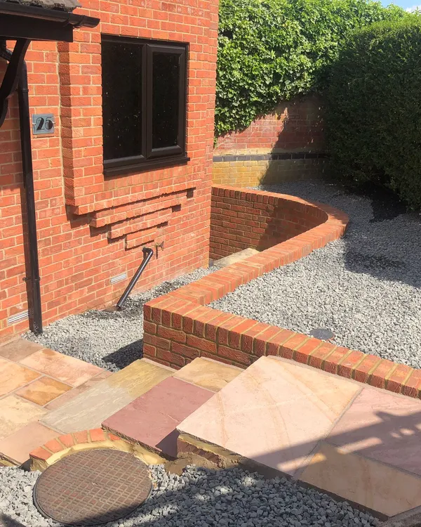 Black composite front door with matching black UPVC windows in a brick property