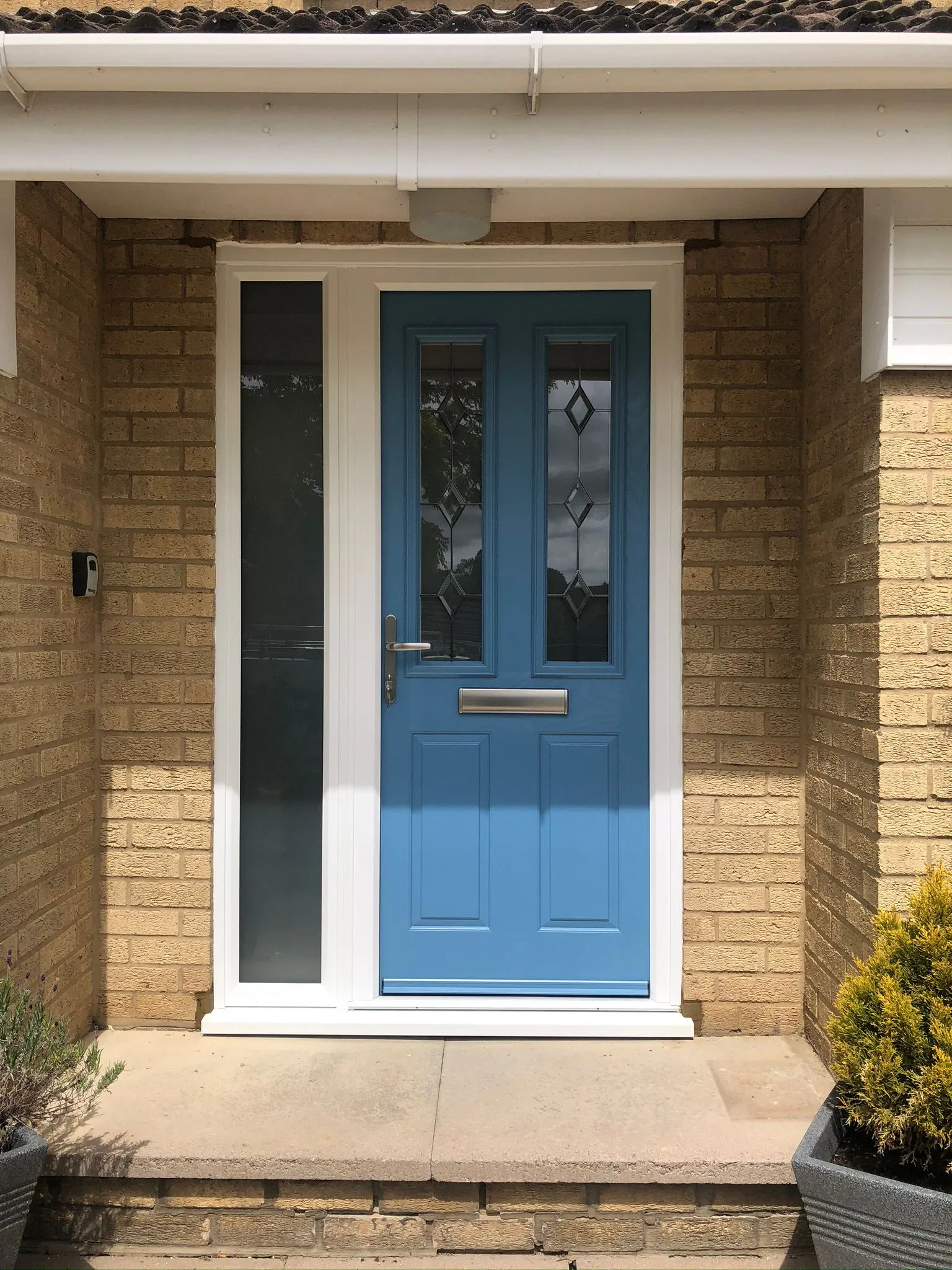 Blue composite front door with decorative glass and frosted side panel