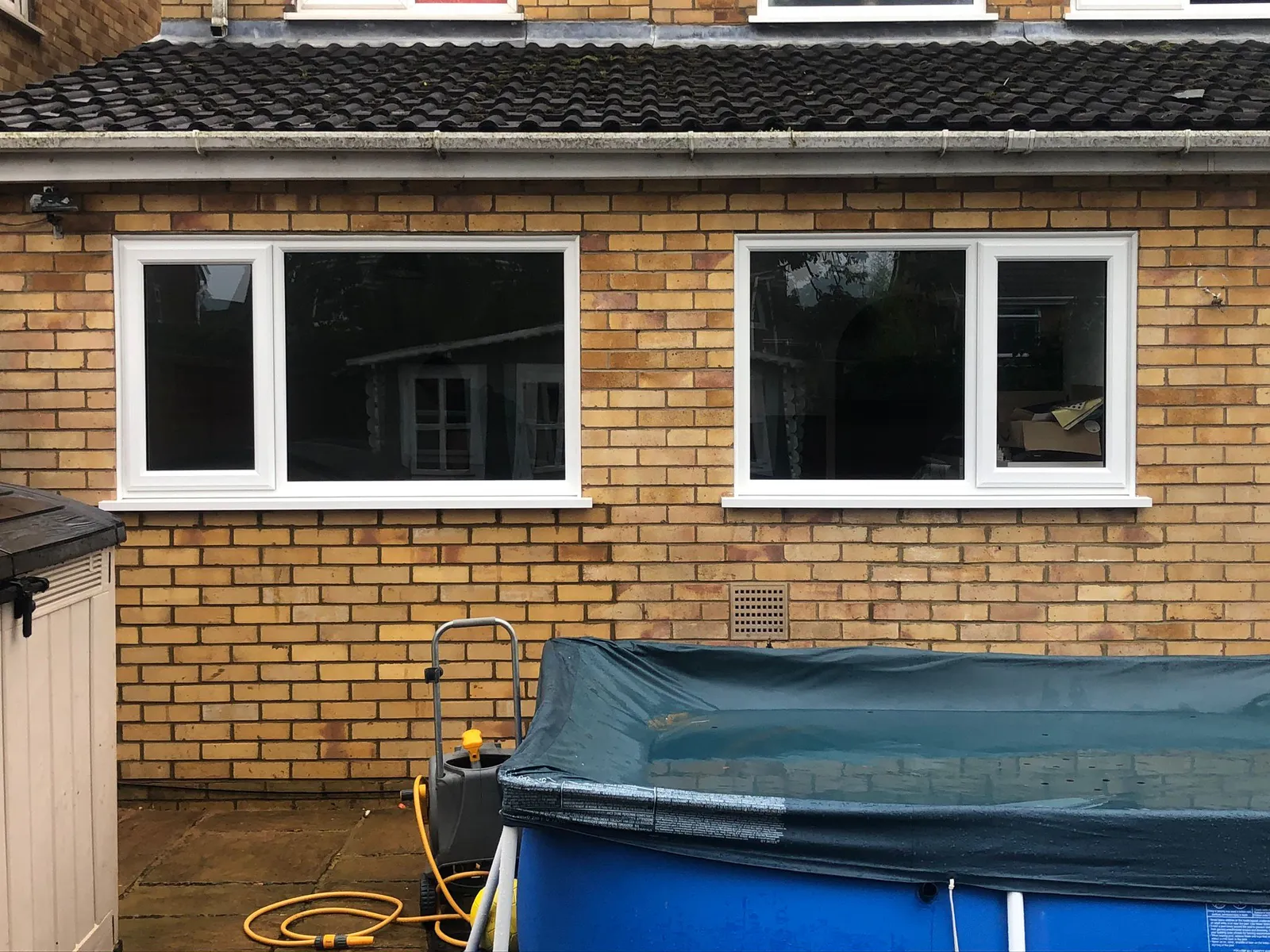White UPVC windows installed on the back of a brick house