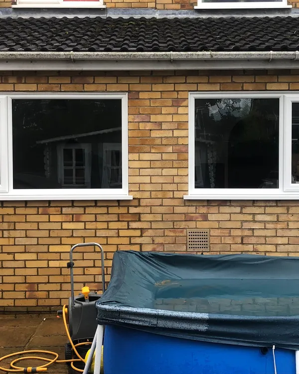 White UPVC windows installed on the back of a brick house