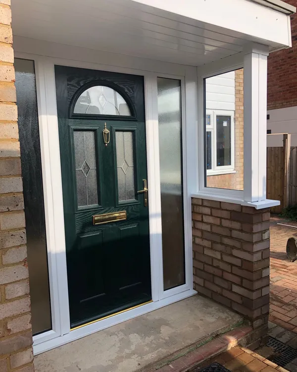 Green composite front door with decorative glazed panels and side windows