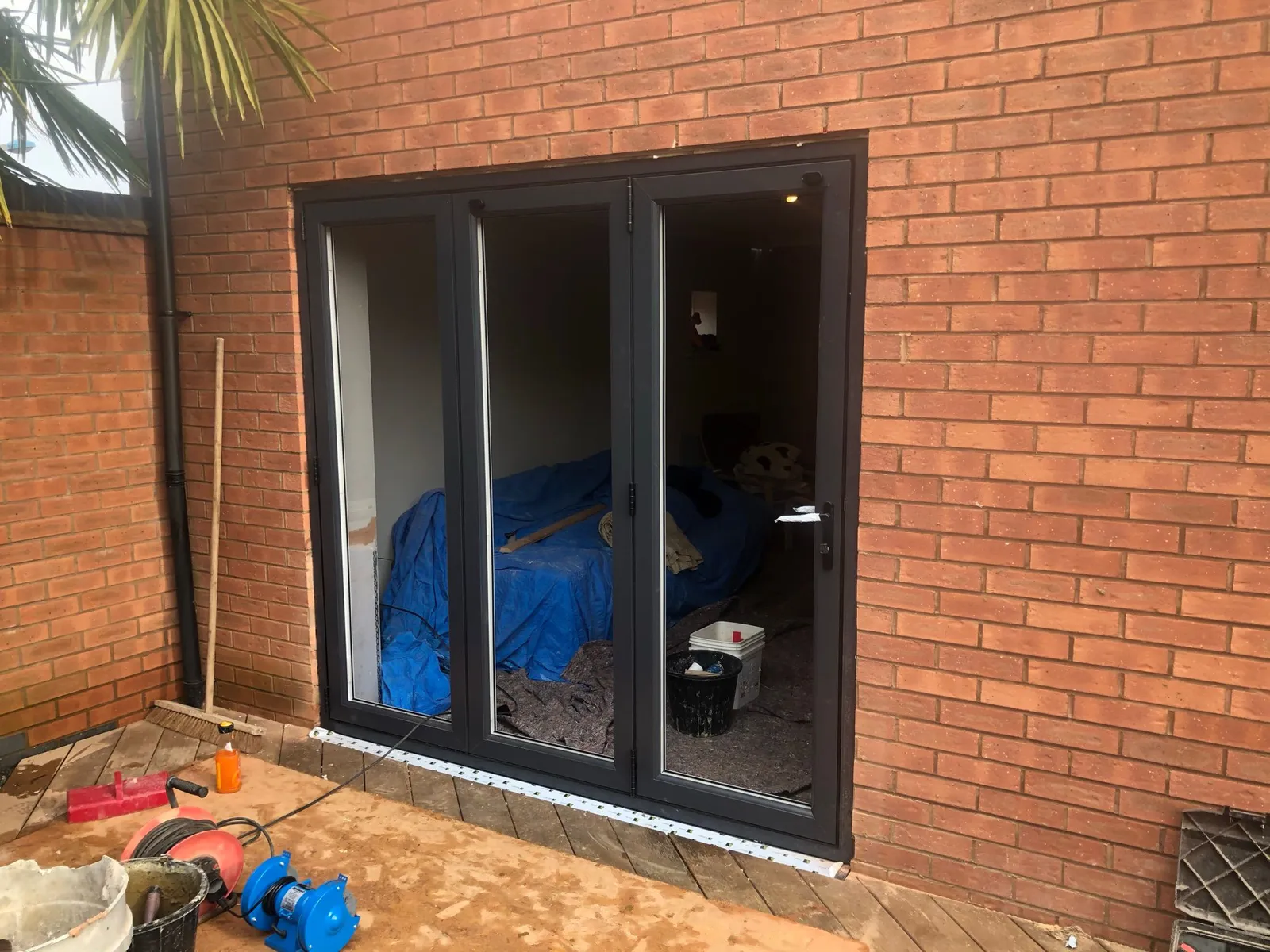 Modern anthracite grey bi-fold doors installed in a brick home