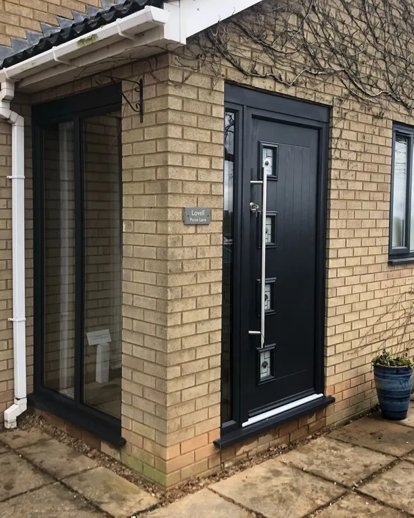 Black composite front door with vertical decorative glazing and chrome handle