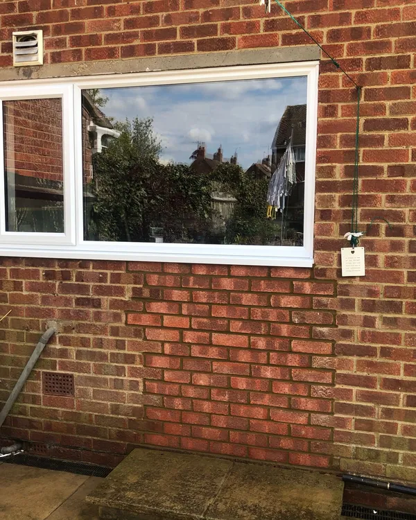 White UPVC casement window installed on a brick wall
