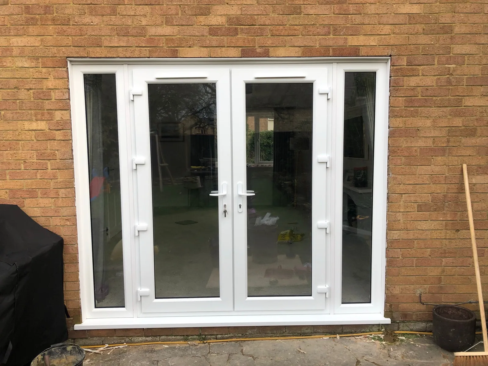 White UPVC French doors with narrow glazed side panels
