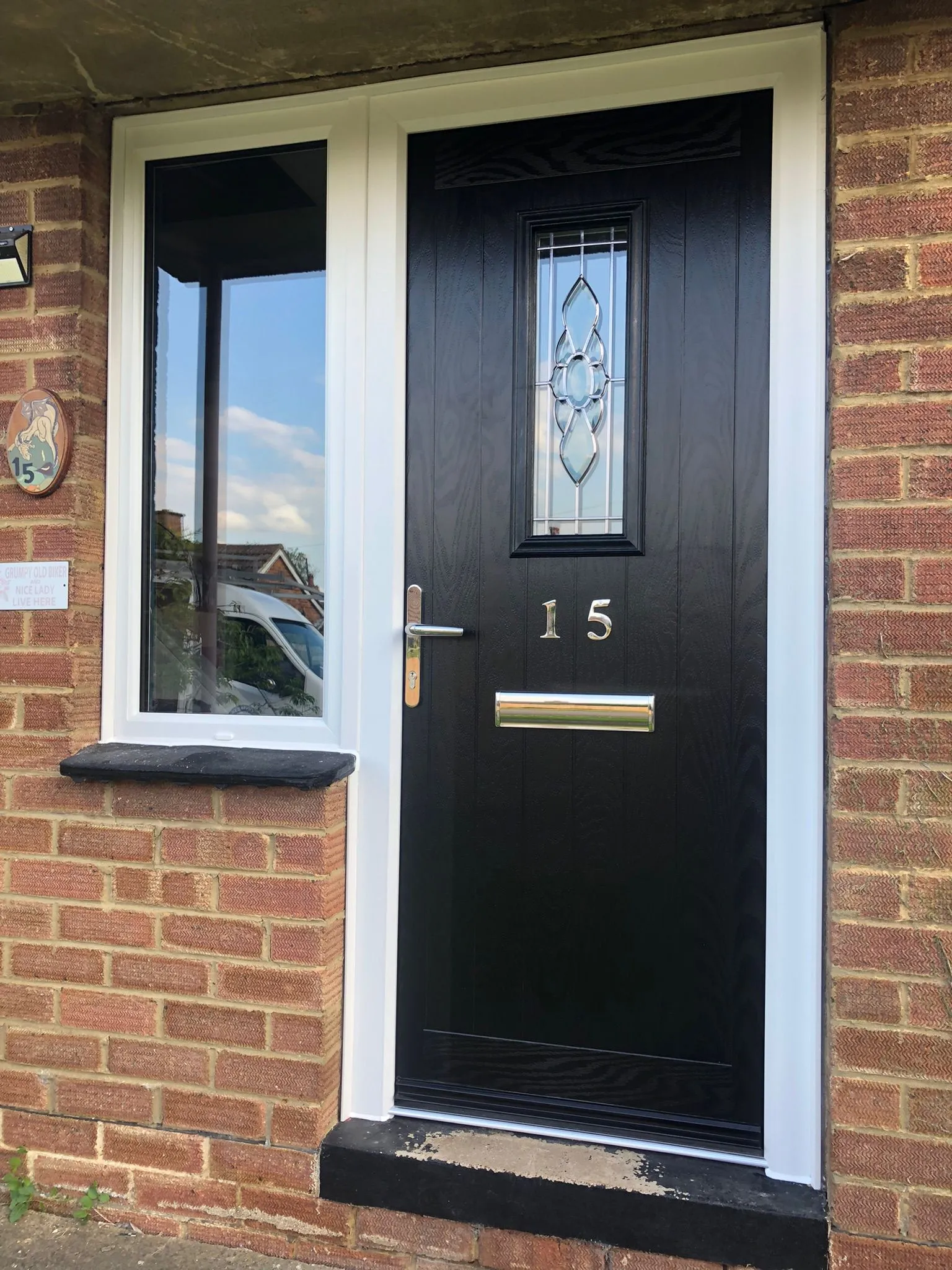 Black composite front door with decorative centre glass and left side window