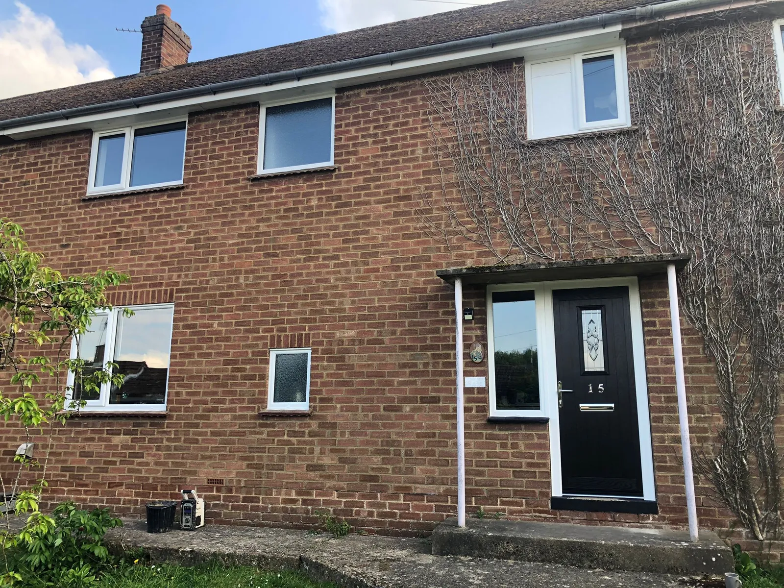 Brick house with new UPVC windows and black composite front door