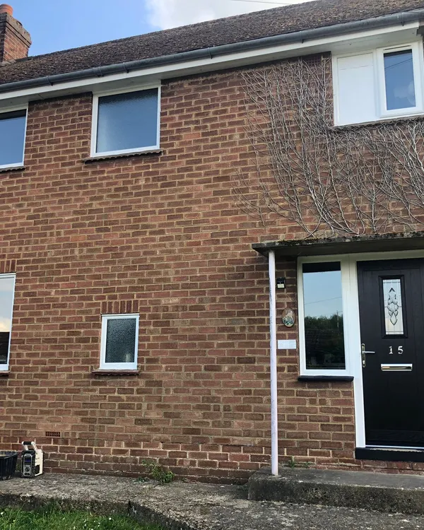 Brick house with new UPVC windows and black composite front door