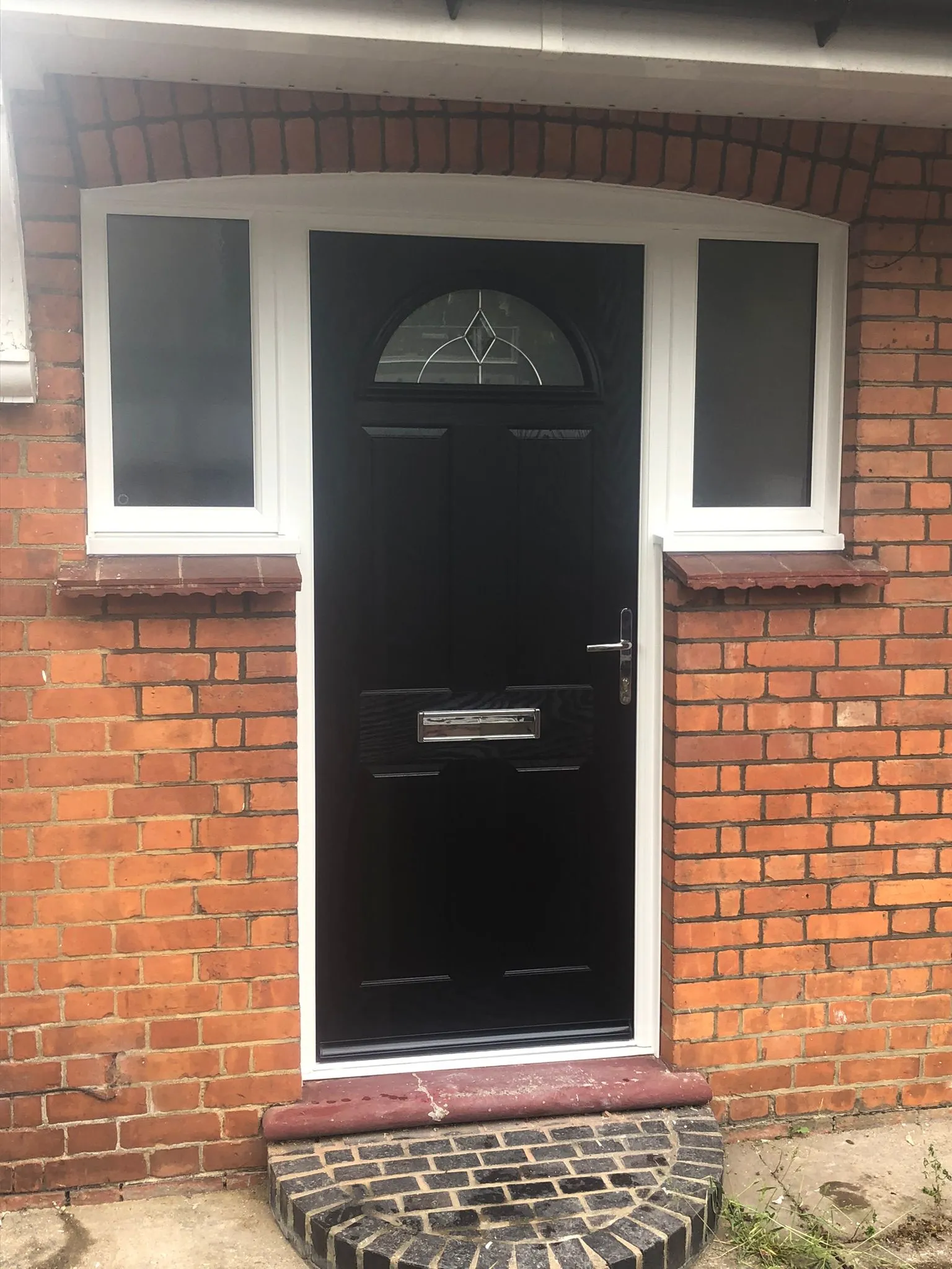 Black composite door with arched glass and frosted side windows