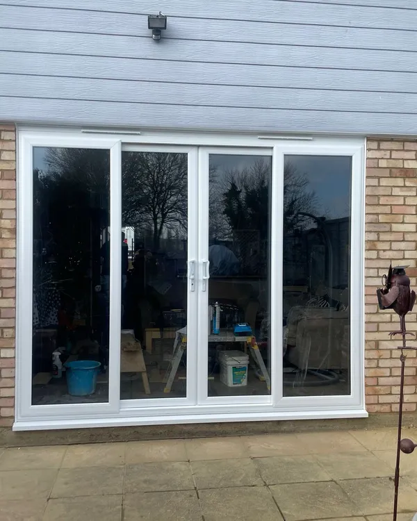 Wide uPVC sliding patio doors in white with glass panels opening to garden patio.
