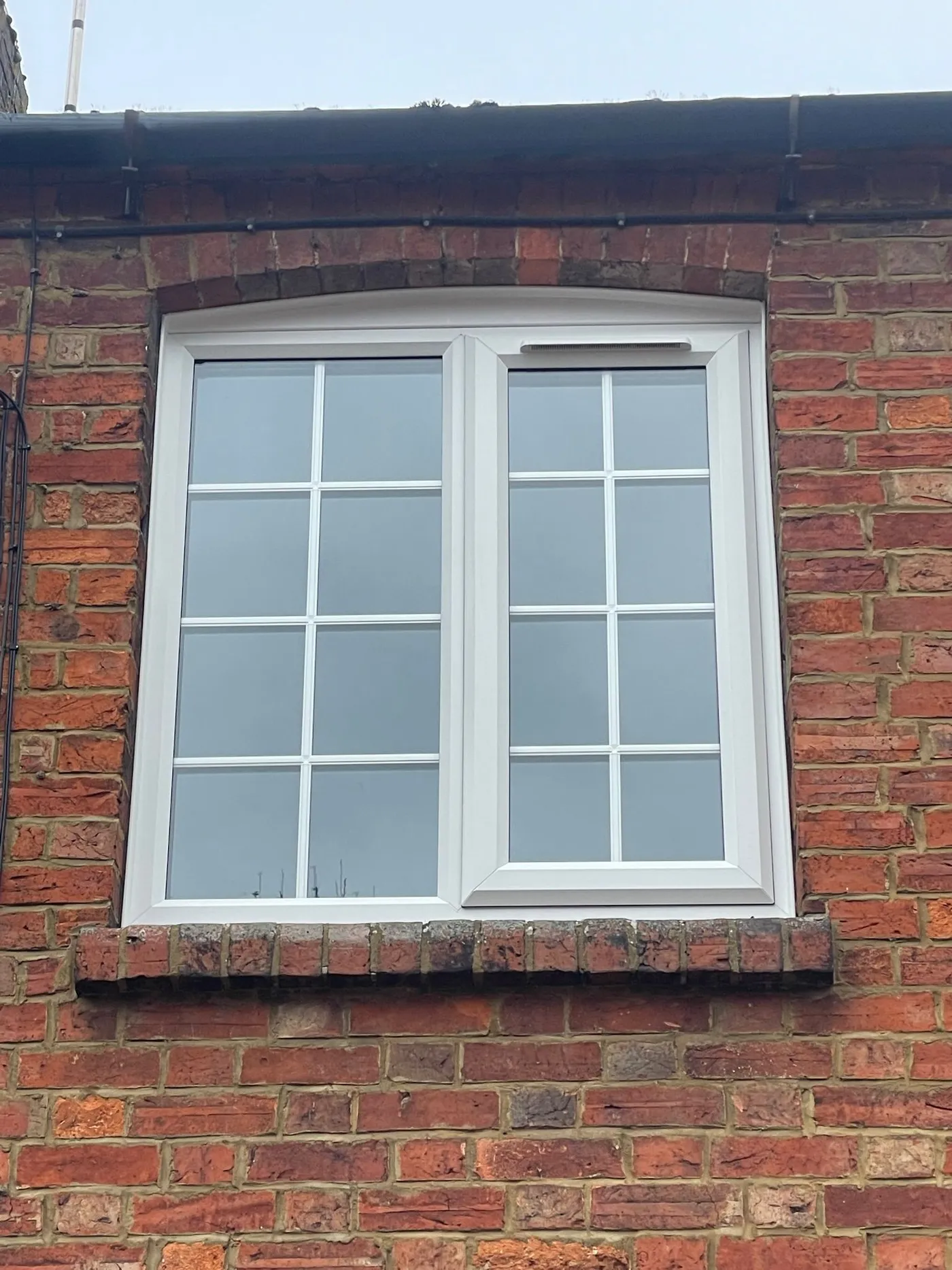 White uPVC casement window with Georgian bar design on first floor.