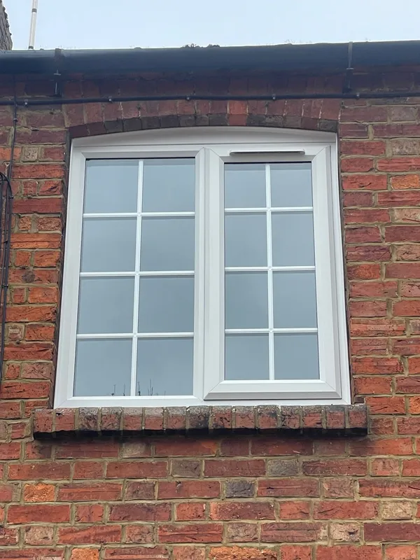 White uPVC casement window with Georgian bar design on first floor.