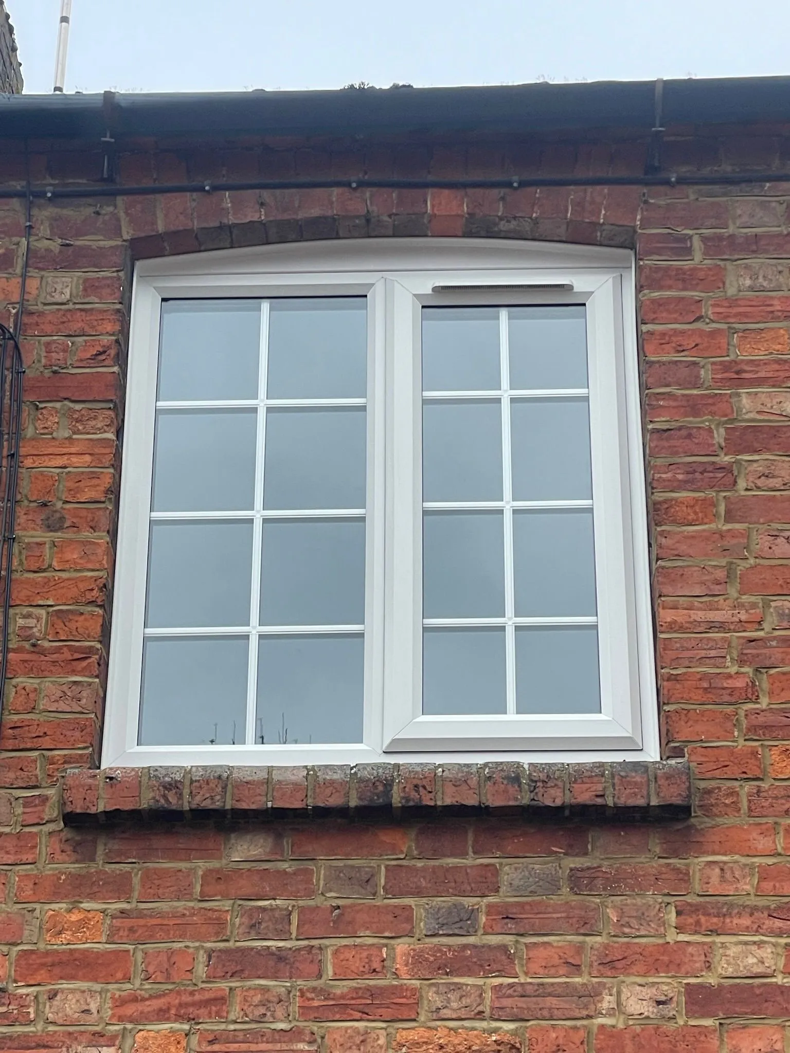 White uPVC double glazed casement window with decorative Georgian bars fitted upstairs.
