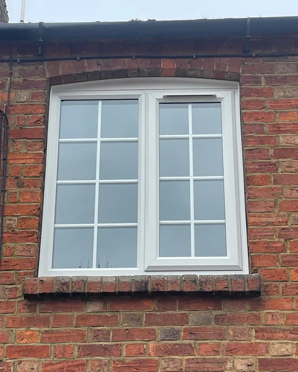 White uPVC double glazed casement window with decorative Georgian bars fitted upstairs.
