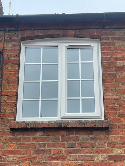 White uPVC casement window with Georgian bar design on first floor.