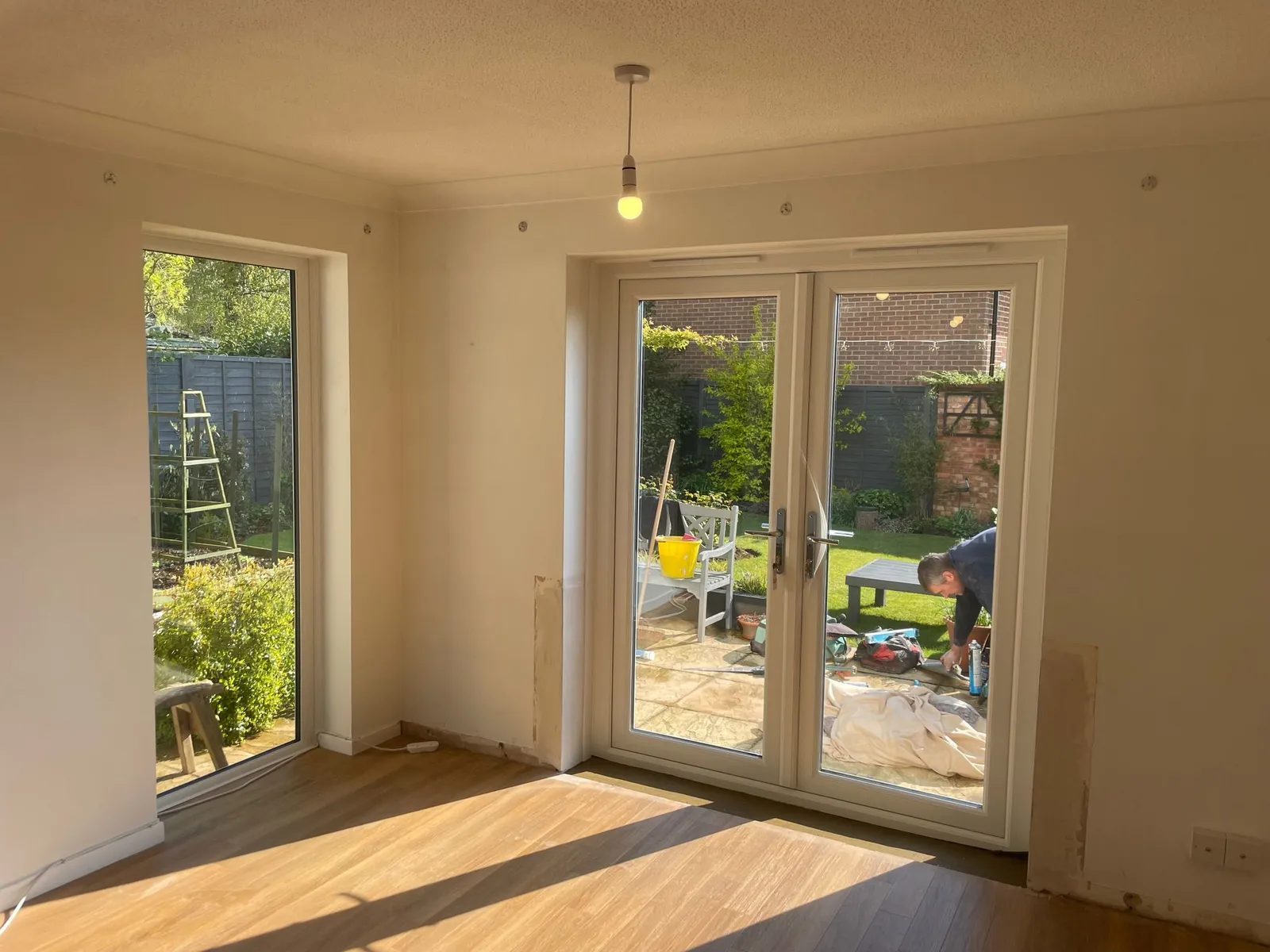 Inside view of white uPVC French doors with glass panes leading to a garden area.