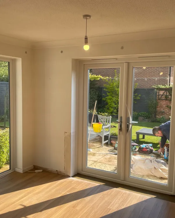 Inside view of white uPVC French doors with glass panes leading to a garden area.