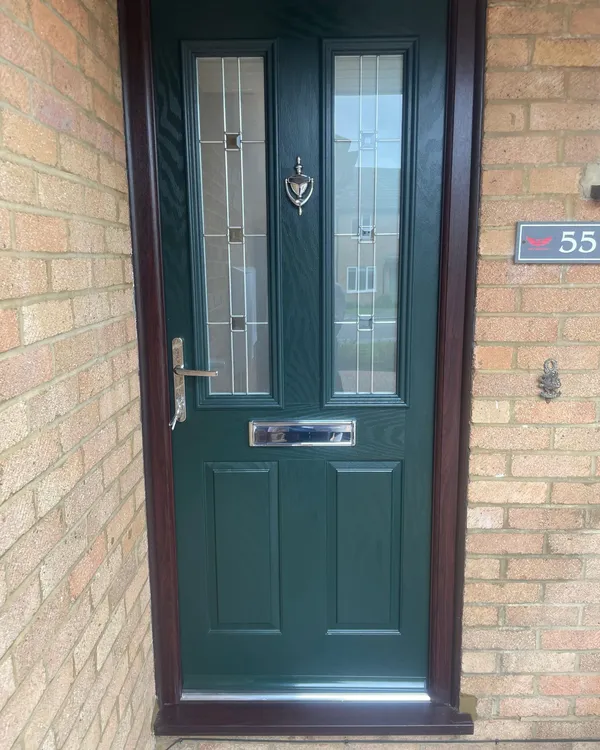 Dark green composite front door with glass inserts and chrome hardware.