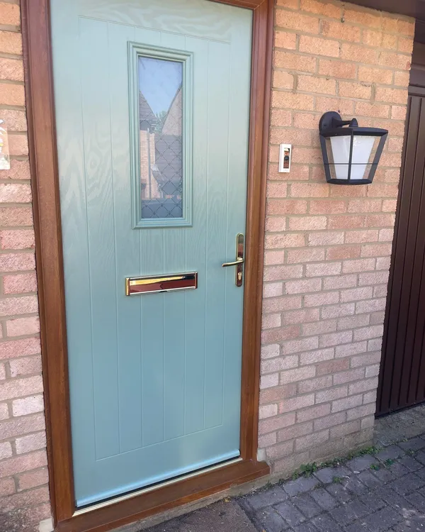 Light blue composite entrance door with square glazed panel and timber effect frame.