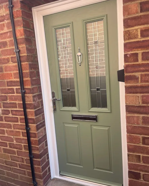 Sage green composite front door with two glass inserts and chrome knocker.