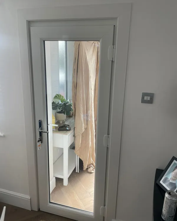 Inside view of white uPVC door with full-length glass panel leading to porch.