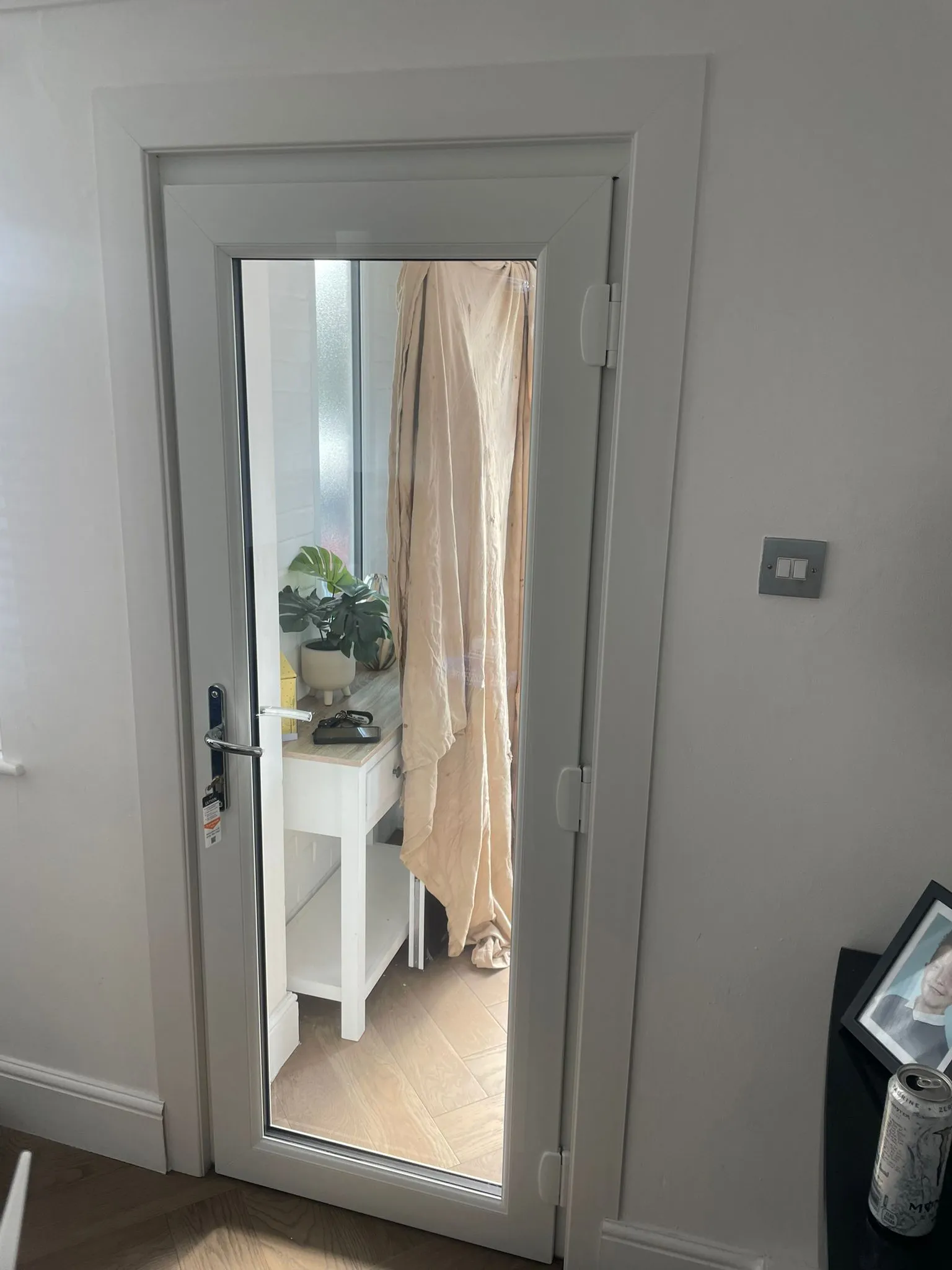 Inside view of white uPVC door with full-length glass panel leading to porch.