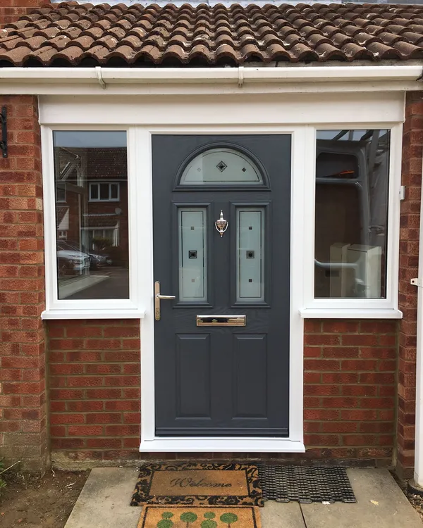 Grey composite front door with decorative glazed panels and UPVC surround