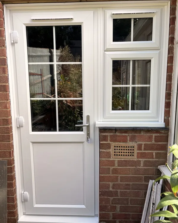 Half-glazed white uPVC back door with Georgian bars, beside a matching white window with a toplight.