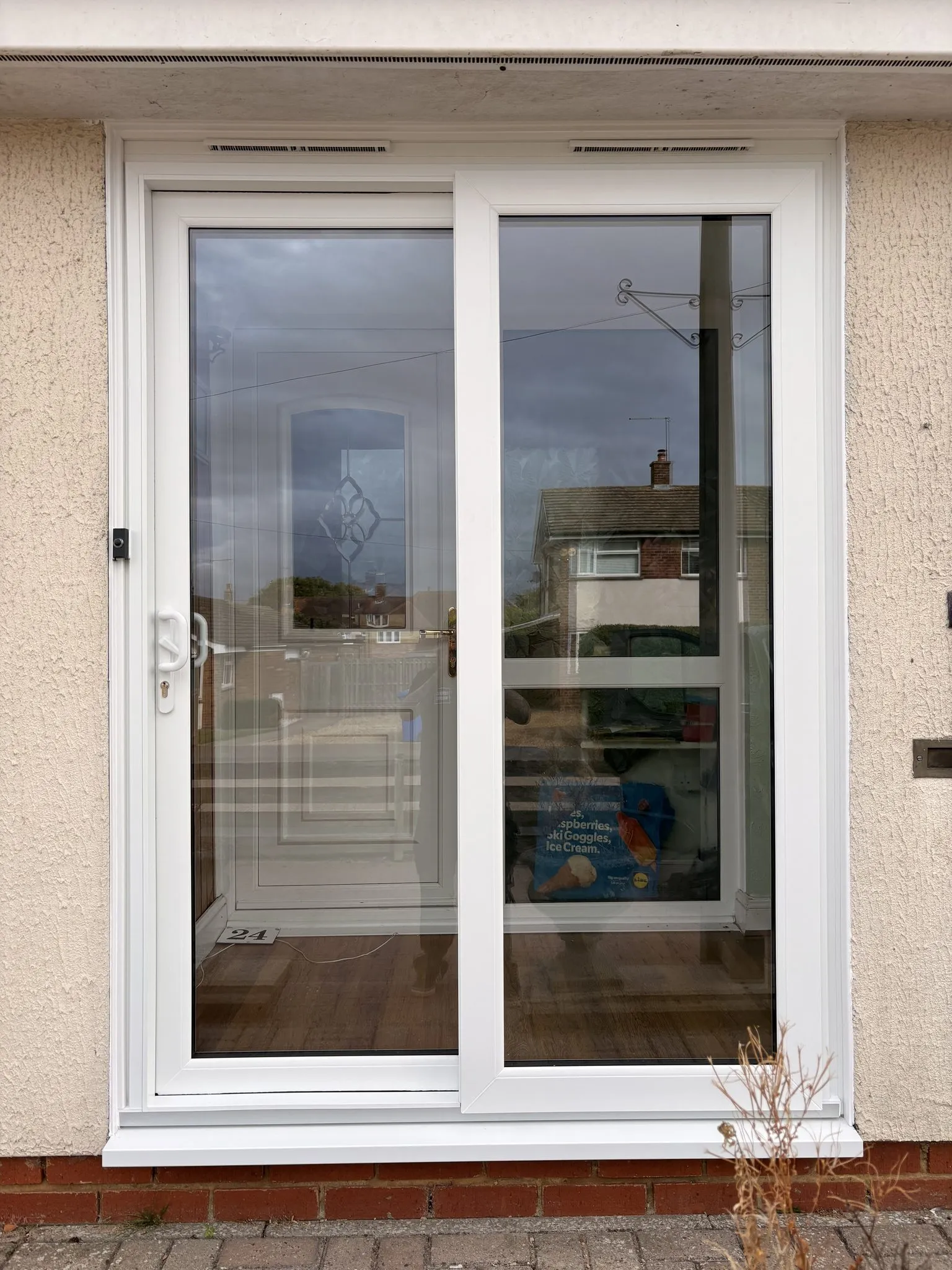 Two-pane white uPVC sliding patio door fitted in a rendered wall.