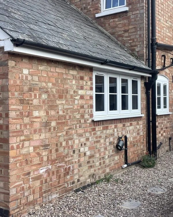 Brick extension fitted with white casement windows and a white glazed stable door.