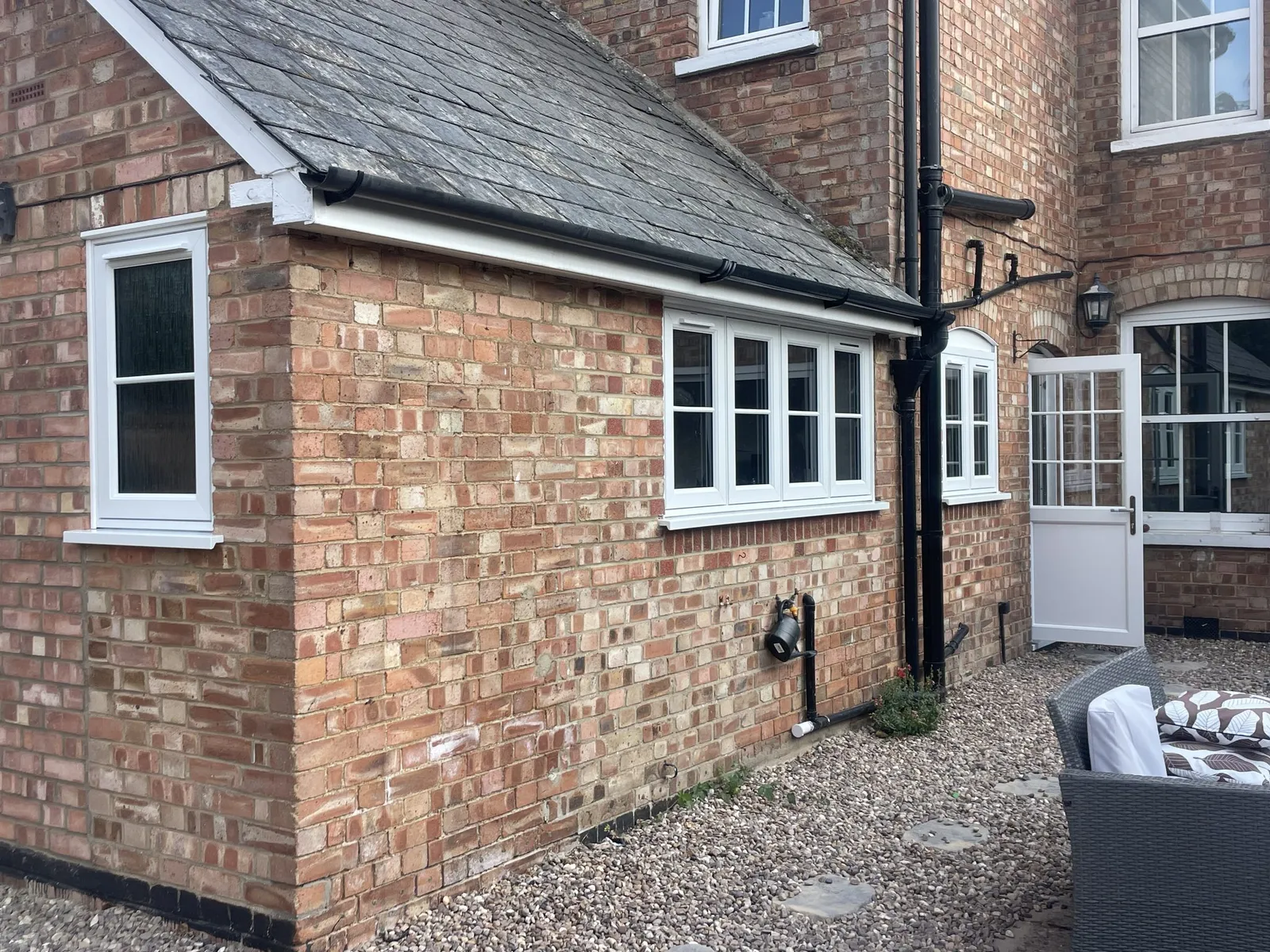 Brick extension fitted with white casement windows and a white glazed stable door.