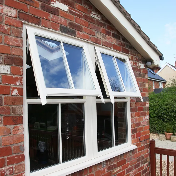 White sash horn windows with the top lights open, on a red brick extension